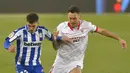 Penyerang Sevilla, Lucas Ocampos, berebut bola dengan bek Alaves, Joaquin Navarro, pada laga lanjutan Liga Spanyol di Stadion Mendizorrotza, Rabu (20/1/2021) dini hari WIB. Sevilla menang 2-1 atas Alaves. (AFP/Ander Gillenea)