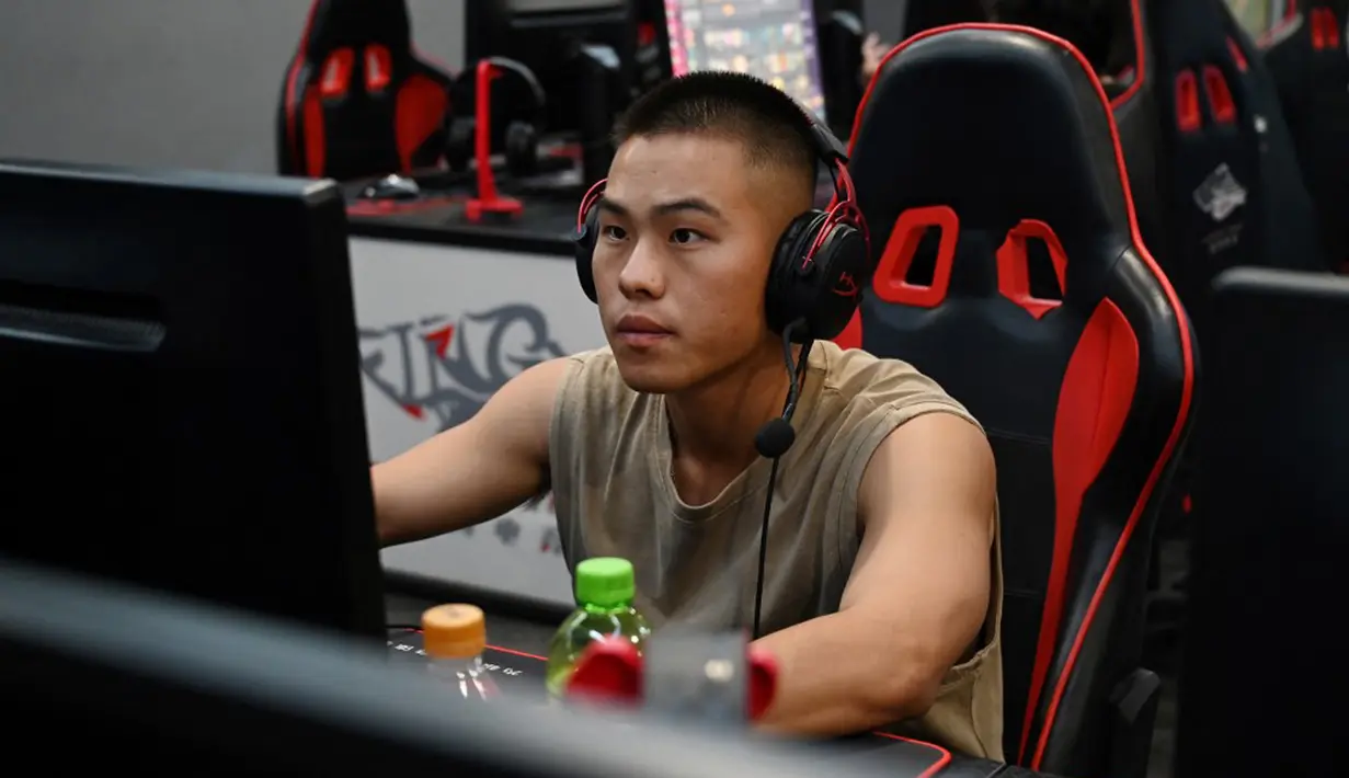 Seorang pria bermain game komputer di sebuah kafe internet di Beijing, China, Jumat (10/9/2021). Anak di bawah 18 tahun di China kini hanya diperbolehkan bermain game online satu jam di hari Jumat, Sabtu, Minggu, dan saat hari libur nasional. (GREG BAKER/AFP)