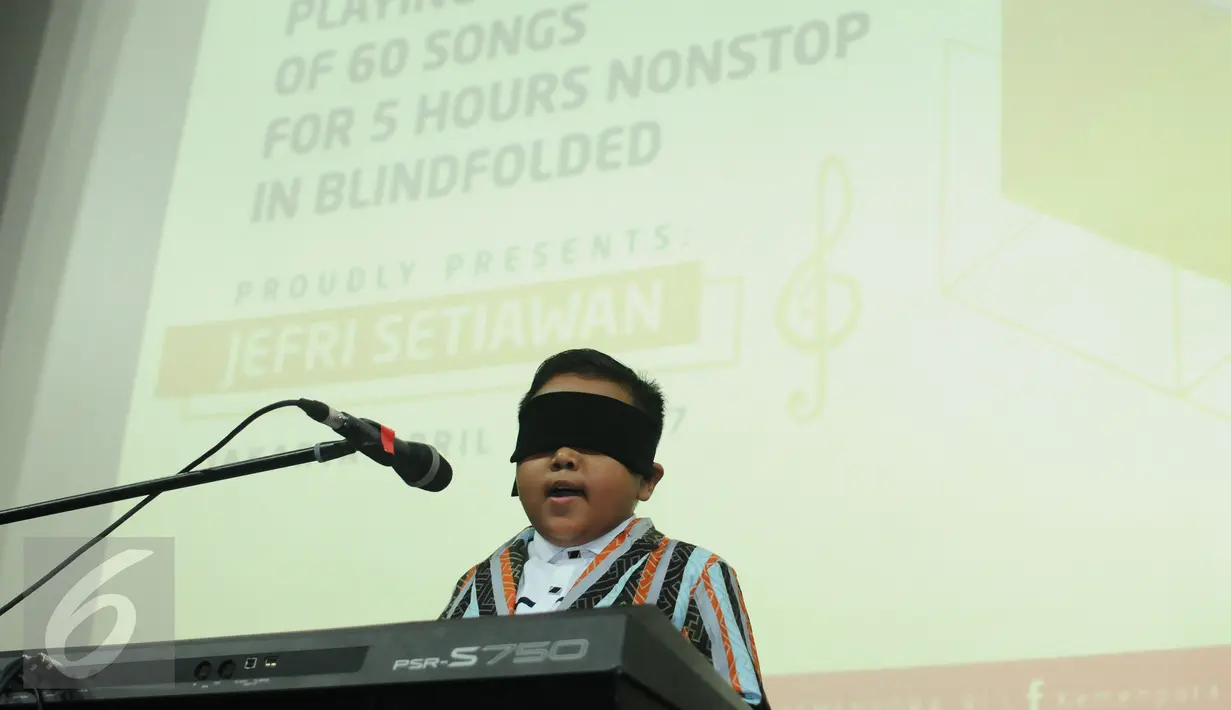 Jefri Setiawan saat menyanyikan lagu di Auditorium Kemenpora, Jakarta, Kamis (14/11). Jefri mencatat rekor dunia baru memainkan 60 lagu menggunakan keyboard dengan mata tertutup. (Liputan6.com/Helmi Fithriansyah)