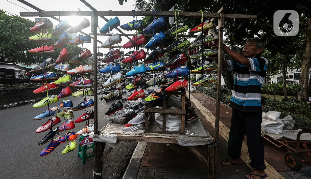 Pedagang sepatu menata barang dagangannya di Tanah Abang, Jakarta Selasa (5/1/2021). Pemerintah mengalokasikan anggaran untuk program pemulihan ekonomi nasional (PEN) 2021 mencapai Rp 403,9 triliun, naik dari rencana sebelumnya sebesar Rp372,3 triliun. (Liputan6.com/Johan Tallo)