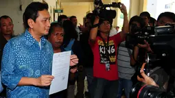 Tersangka kasus korupsi pengadaan bus TransJakarta Udar Pristono menunjukan berkas sebelum menjalani sidang praperadilan kepada wartawan di Pengadilan Negri Jakarta Pusat, Rabu (18/3/2015). (Liputan6.com/Yoppy Renato)