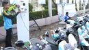 Petugas mengisi daya motor listrik yang dipamerkan di Kawasan JCC di Jakarta, Minggu (3/12). Inovasi-inovasi ini diharapkan dapat meningkatkan kinerja PLN dalam memberikan pelayanan kepada masyarakat. (Liputan6.com/Angga Yuniar)