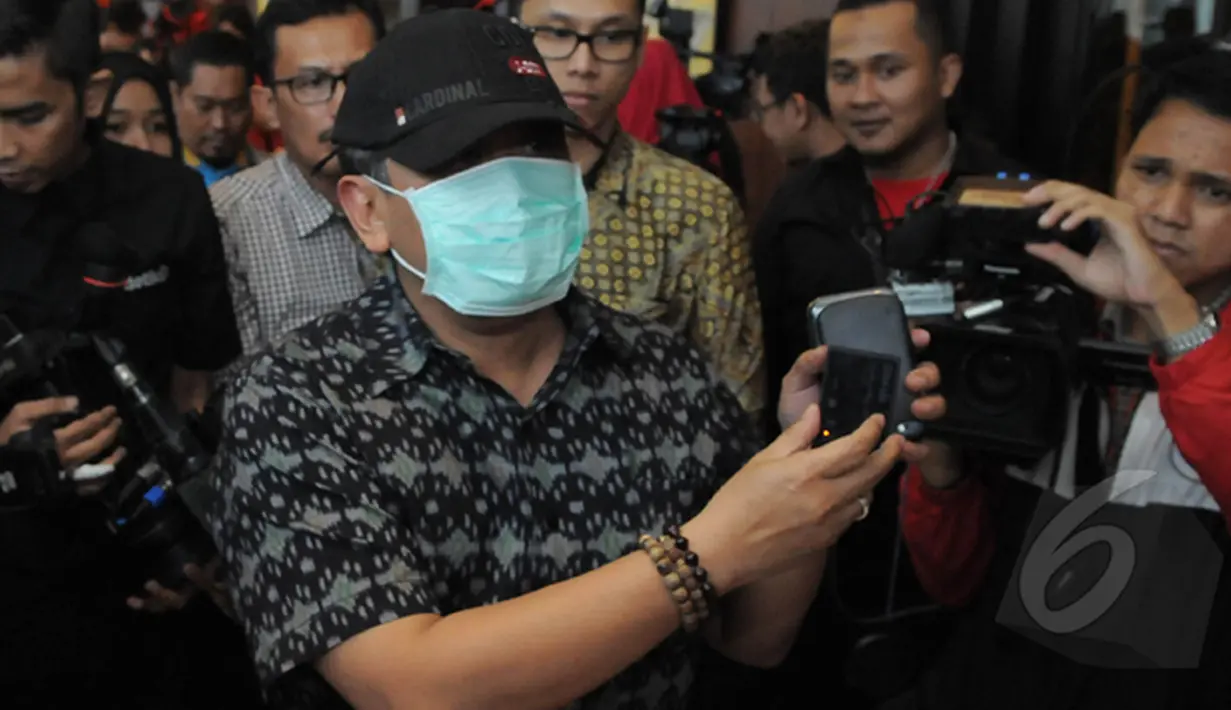 Hasto Kristiyanto menggunakan masker dan topi menunjukkan alat anti sadap telepon genggam saat menggelar konferensi pers di Jakarta, Kamis (22/1/2015). (Liputan6.com/Herman Zakharia)