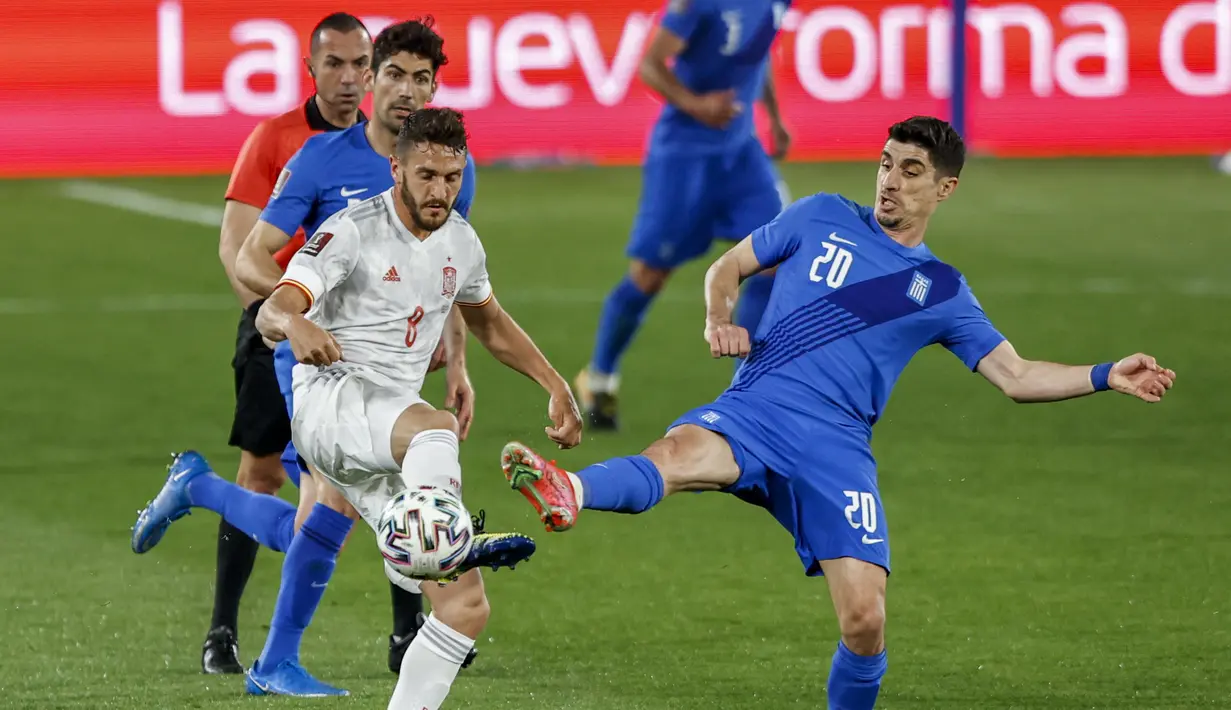 Gelandang Timnas Spanyol, Jorge Koke berebut bola dengan gelandang Yunani, Petros Mantalos pada kualifikasi Piala Dunia 2022 zona Eropa Grup B di stadion Los Carmenes , Granada, Jumat (26/3/2021) dinihari WIB. Spanyol tertahan 1-1 saat menjamu Yunani. (AP Photo/Fermin Rodriguez)