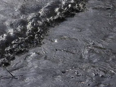 Tumpahan minyak menutupi pantai di pantai Cavero di Ventanilla, Callao, Peru, Senin (17/1/2022). Otoritas setempat dan pekerja kilang La Pampilla membersihkan tumpahan minyak yang terjadi akibat gelombang tsunami yang dipicu letusan gunung api bawah laut di Tonga.  (AP Photo/Martin Mejia)