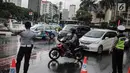 Polisi dan petugas Dishub mengalihakan arus lalu lintas terkait Malam Munajat 212 di Medan Merdeka Barat dan Utara, Jakarta, Kamis (21/2). Masyarakat yang akan melintasi kawasan Monas diharapkan mencari jalur alternatif. (Liputan6.com/Faizal Fanani)