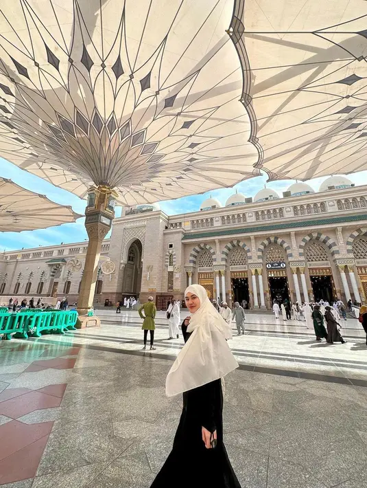 Penampilan anggun Aaliyah Massaid saat menjalankan ibadah Umroh di Masjib Nabawi. Ia mengenakan gamis hitam polos, yang dipadukannya dengan hijab panjang berwarna putih. [Foto: Instagram/aaliyah.massaid]