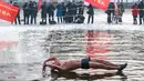 Seorang penggemar renang musim dingin menyelam ke danau yang sebagian beku di Shenyang, provinsi Liaoning, China pada 25 Januari 2022. Berenang di musim dingin adalah kegiatan olahraga yang jarang dijumpai kecuali di beberapa negara dengan musim dingin yang cukup panjang. (STR/AFP)