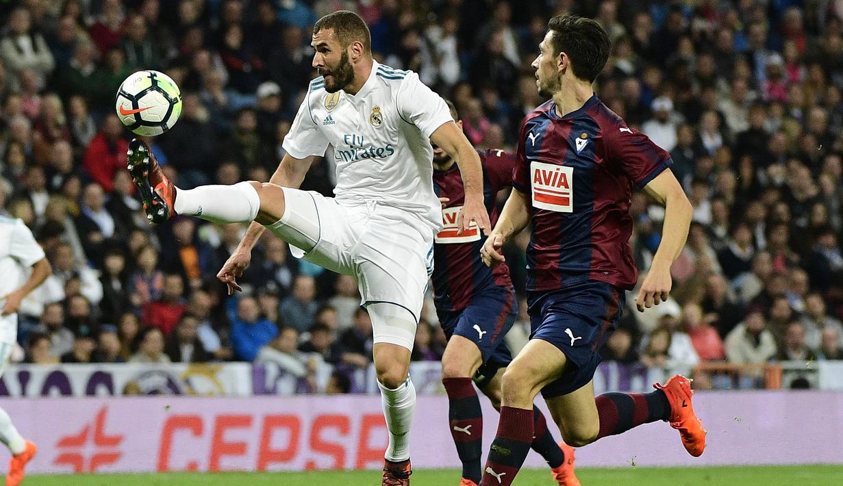 Pemain Real Madrid, Karim Benzema (kiri) berusaha melewati adangan para pemain Eibar pada lanjutan La Liga Santander di Santiago Bernabeu stadium, Madrid, (22/10/2017). Madrid menang 3-0. (AFP/Pierre-Philippe Marcou)