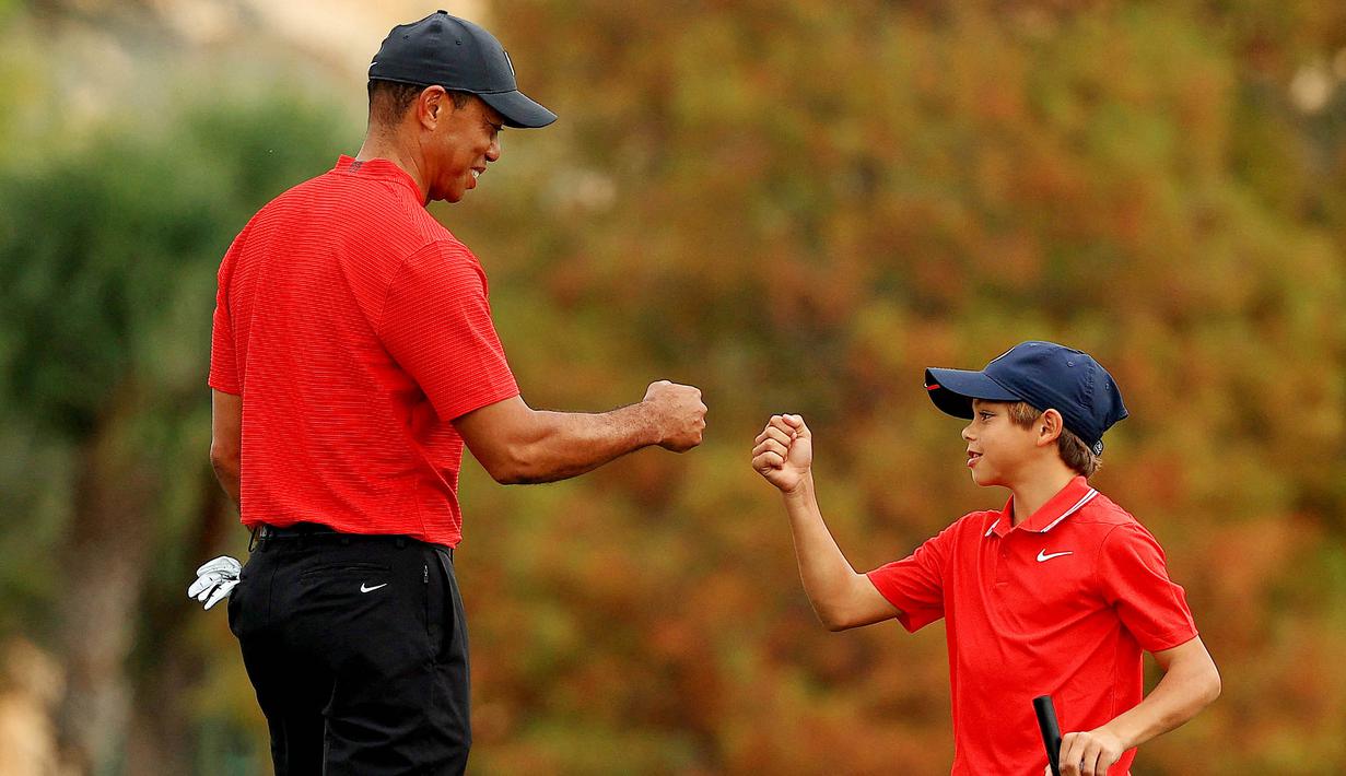 Maestro golf Tiger Woods tampak begitu dekat dengan anaknya yang bernama Charlie Axel Woods. (Mike Ehrmann/Getty Images/AFP)