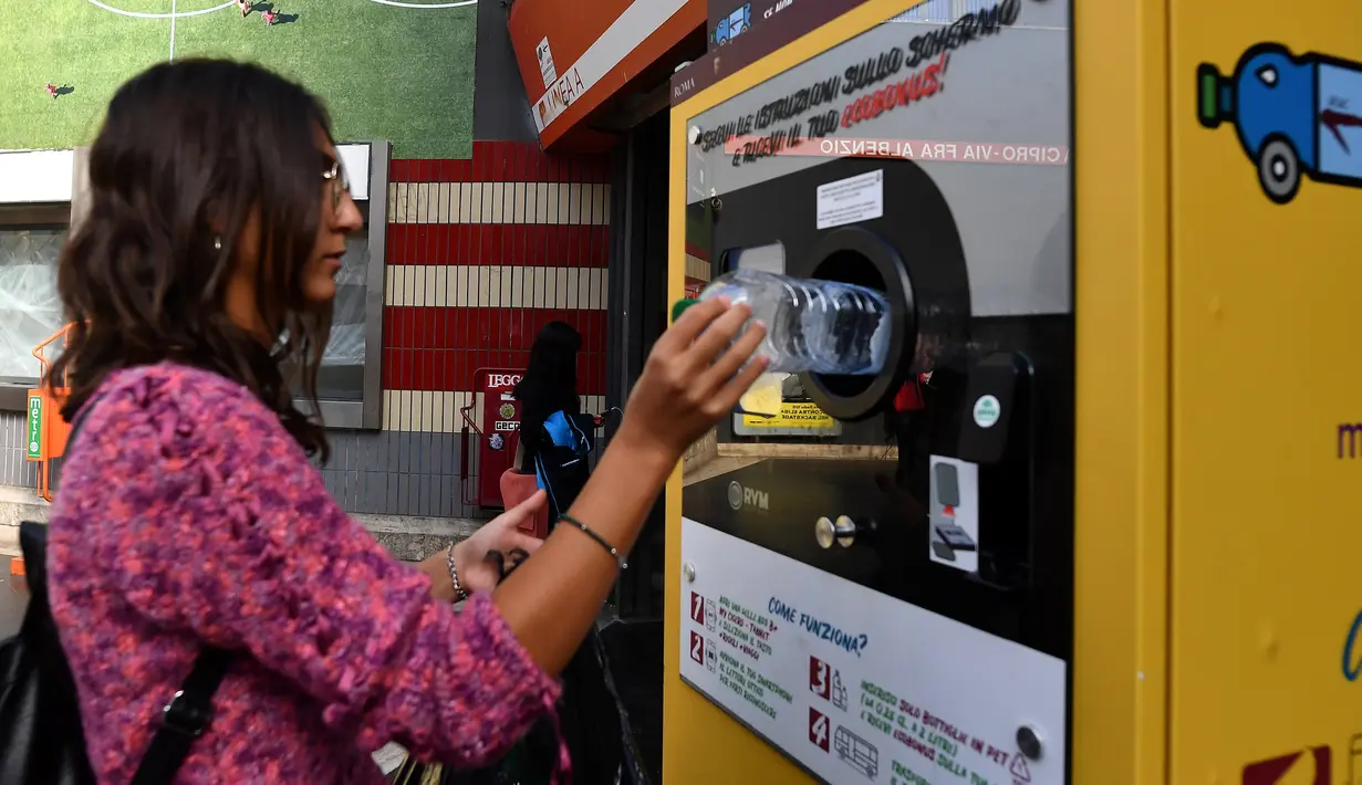 Seorang calon penumpang menukarkan sampah botol plastik dengan tiket kereta menggunakan mesin daur ulang di stasiun metro bawah tanah Cipro, Roma, Selasa (8/10/2019). (Photo by Tiziana FABI / AFP)