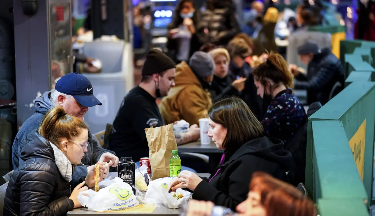 Pelanggan makan di Reading Terminal Market di Philadelphia, Rabu (16/2/2022). Pejabat kota Philadelphia mencabut mandat vaksin untuk makan di dalam ruangan dan tempat lain yang menyajikan makanan dan minuman, tetapi mandat masker dalam ruangan tetap berlaku. (AP Photo/Matt Rourke)