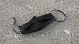Masker wajah bekas yang kotor ditinggalkan di tanah di taman Tuileries, Paris, Senin (14/3/2022). Prancis telah mencabut sebagian besar pembatasan COVID-19 pada hari Senin, memungkinkan orang melepas masker di hampir semua tempat. (AP Photo/Francois Mori)