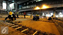 Pekerja saat merakit besi untuk perbaikan dan perawatan jalan 'Underpass' di kawasan Pondok Indah, Jakarta, Selasa (28/11). Perbaikan dan perawatan jalan tersebut guna mengantisipasi musim hujan. (Liputan6.com/Helmi Afandi)