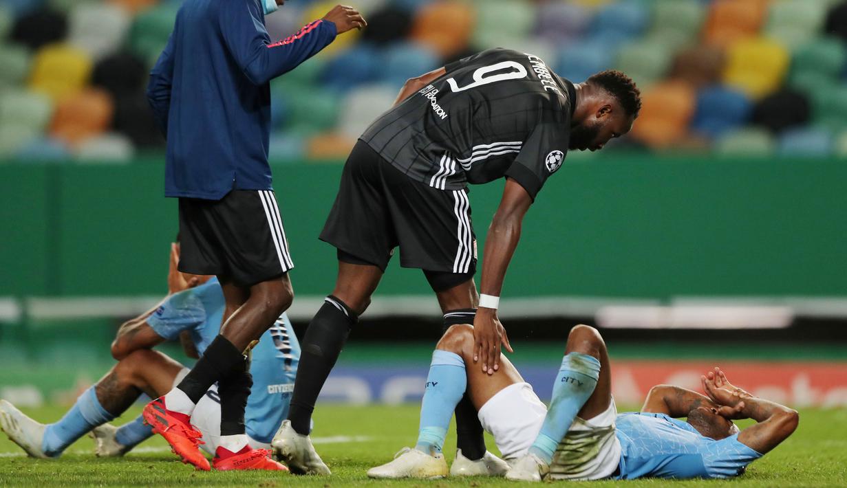 Pemain Lyon, Moussa Dembele, berusaha menguatkan striker Manchester City, Raheem Sterling, usai ditaklukkan pada perempat final Liga Champions di Stadion Jose Alvalade, Sabtu (15/8/2020). Lyon menang 3-1 atas Manchester City. (Miguel A. Lopes/Pool via AFP)