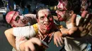 Sejumlah peserta mengenakan kostum menyerupai zombie berpose saat difoto dalam perayaan hari Purim di Tel Aviv (11/3). Perayaan ini sebagai bentuk peringatan orang Yahudi bebas dari rencana jahat Haman. (AFP/Jack Guez)