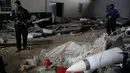 Pasukan khusus Irak berjaga dekat rudal yang ditemukan di sebuah gudang senjata milik ISIS di sisi timur Mosul, Sabtu (28/1). Gudang itu berisi puluhan roket peninggalan mantan diktator Irak Saddam Hussein dan gas mustard. (AP Photo/Khalid Mohammed)