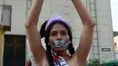 Aktivis memborgol tangan sambil bertelanjang dada saat menggelar aksi Hari Internasional untuk Penghapusan Kekerasan terhadap Perempuan di Lima, Peru, Rabu (25/11). Mereka menuntut legalisasi aborsi dalam kasus pemerkosaan. (AFP PHOTO/CRIS BOURONCLE)