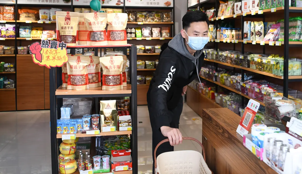 Seorang pria bekerja di toko makanan ringan miliknya di Distrik Xiling, Kota Yichang, Provinsi Hubei, China, Jumat (20/3/2020). Berbagai retail dan pusat perbelanjaan secara bertahap melanjutkan aktivitasnya setelah meredanya kasus virus corona COVID-19 di China. (Xinhua/Cheng Min)