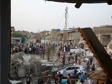 Orang-orang memeriksa tempat kejadian setelah ledakan di Kota Sadr di Baghdad, Irak, (7/6). Menurut pejabat setempat, sepasang ledakan bom menghancurkan sebuah masjid di distrik mayoritas Syiah di ibukota Irak. (AP Photo/Karim Kadim)