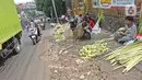 Pedagang menyelesaikan pembuatan kulit ketupat di kawasan Cibubur, Jakarta, Rabu (30/7/2020). Pedagang musiman menjelang Idul Adha tersebut menjual kulit ketupat dengan harga Rp 10 ribu, sedangkan ketupat yang siap untuk dihidangkan seharga Rp 30 ribu. (Liputan6.com/Herman Zakharia)