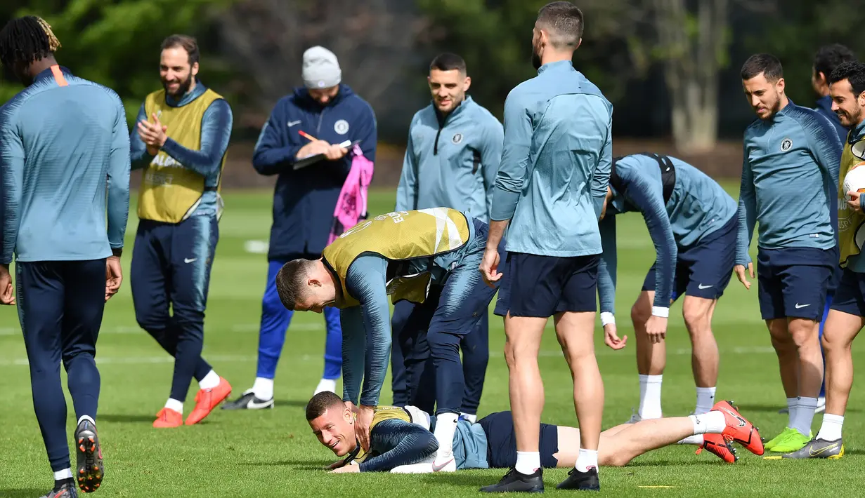 Bek Chelsea, Gary Cahill (tengah) membantu gelandang Ross Barkley berdiri selama sesi latihan tim di Stoke D'Abernon, London (8/5/2019). Pada leg pertama Chelsea bermain imbang 1-1 atas Eintracht Frankfurt di Jerman. (AFP Photo/Ben Stansall)