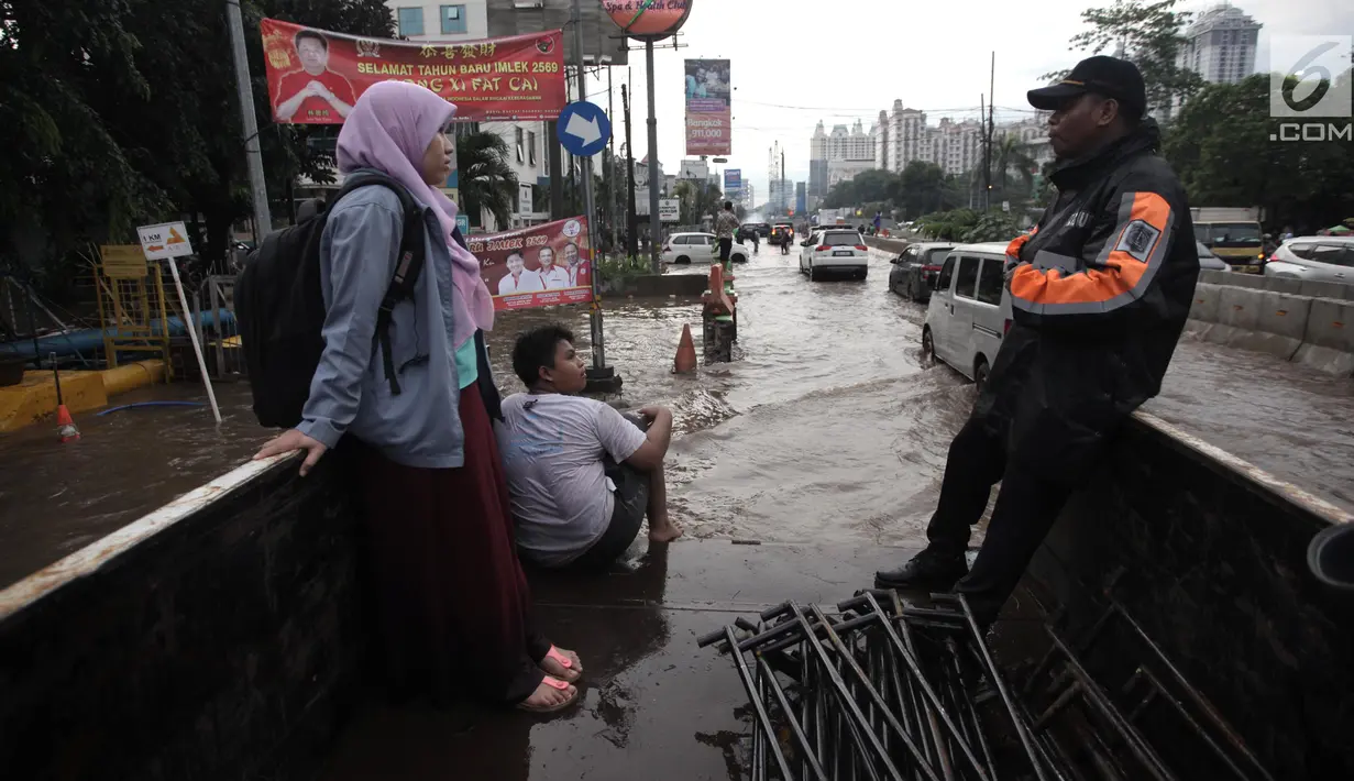 Petugas Dinas Perhubungan (Dishub) mengevakuasi karyawan dan warga yang terjebak banjir di Jalan Boulevard Raya, Kelapa Gading, Jakarta, Kamis (15/2). Banjir diakibatkan guyuran hujan sejak pagi hingga sore. (Liputan6.com/Arya Manggala)