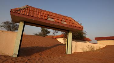Pintu masuk sebuah rumah yang setengah terkubur di gurun pasir, di desa terlantar Al-Madam, berbatasan dengan Emirat Teluk Sharjah, Kamis (22/4/2021). Al Madam adalah sebuah kota kecil berjarak 60 kilometer dari kota Dubai yang terlantar ditinggalkan sejak lama oleh penduduknya (GIUSEPPE CACACE/AFP