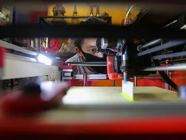 Karyawan melihat pola kerja pembuatan face shield atau pelindung wajah pada mesin print 3D di IMA 3D, Cipondoh, Kota Tangerang, Kamis (23/4/2020). Face shield untuk tenaga medis ini di donasikan bagi sejumlah rumah sakit yang membutuhkan tanpa dipungut biaya. (Liputan6.com/Fery Pradolo)