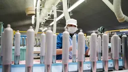 Seorang pekerja melakukan pengujian kualitas kondom di Sagami Rubber Industries, Prefektur Kanagawa, Jepang (25/1). Sambut Olimpiade 2020, Jepang akan memamerkan produk lokal kondom yang ultra tipis. (AFP Photo/Behrouz Mehri)