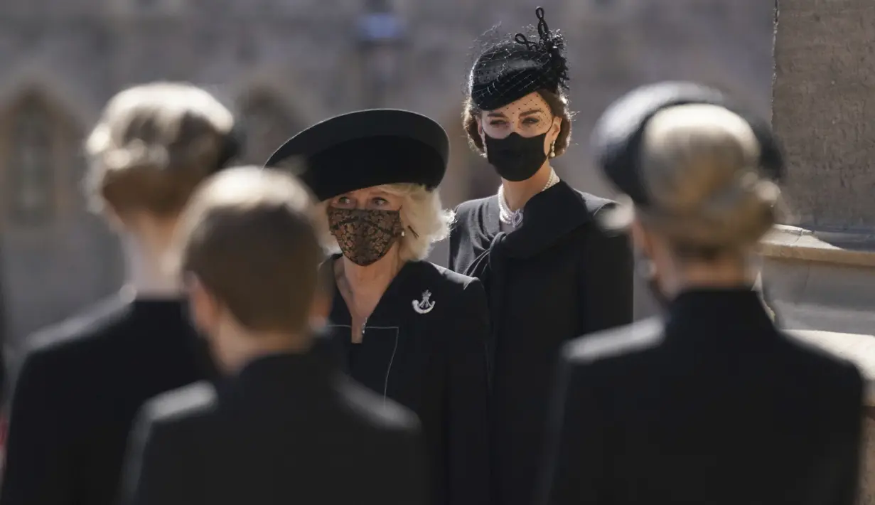 Kate Middletone, Duchess of Cambridge berdiri menjelang pemakaman Pangeran Philip di kastil Windsor, Inggris (17/4/2021). Kate Middletone, Duchess of Cambridge tampil memesona dengan busana dan masker hitam. (Victoria Jones/Pool via AP)