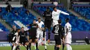 Bek Real Madrid, Raphael Varane (kanan) berusaha menyundul bola saat bertanding melawan Borussia Monchengladbach pada Grup B Liga Champions di Estadio Alfredo Di Stefano, Kamis (10/12/2020). Kemenangan ini mengantar Madrid lolos ke babak 16 besar Liga Champions. (AFP/PIERRE-PHILIPPE MARCOU)