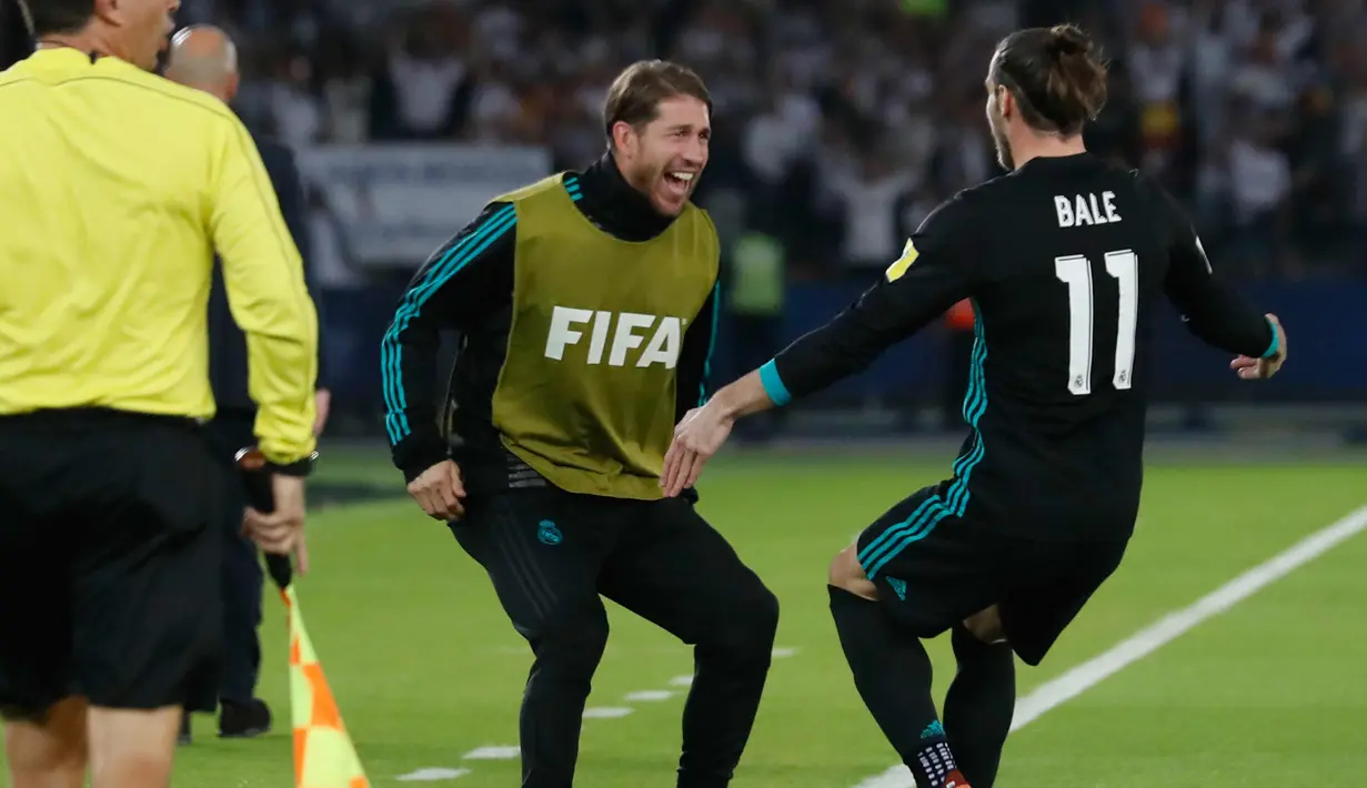 Penyerang Real Madrid, Gareth Bale menghampiri rekannya Sergio Ramos usai mencetak gol ke gawang Al Jazira di semifinal Piala Dunia Antarklub di Syekh Zayed Sports City Stadium, (14/12). Los Blancos menang dengan skor 2-1. (AP Photo/Hassan Ammar)