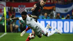 Pemain Kroasia, Ante Rebic melakukan tackling terhadap bek timnas Inggris, Danny Rose pada babak semifinal Piala Dunia 2018 di Stadion Luzhniki, Rabu (11/7). Rose menyita perhatian lantaran mengenakan kaus kaki yang berlubang. (AFP/ MANAN VATSYAYANA)