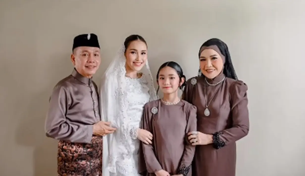 Rambutnya ditata dengan gaya sleek look dan ditutup dengan kerudung putih yang cantik. [Foto: Instagram/mom_ayting92_]