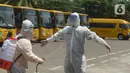 Petugas disemprot disinfektan sebelum menjemput pasien Covid-19 menggunakan bus sekolah di Puskesmas Jatinegara, Jakarta, Selasa (22/9/2020). Bus sekolah Pemprov DKI kini dialihfungsikan menjadi kendaraan untuk mengantar pasien Covid-19 berstatus OTG menuju Wisma Atlet. (merdeka.com/Imam Buhori)