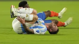 Gelandang Timnas Argentina, Alexis Mac Allister mengerang kesakitan usai berbenturan dengan seorang pemain Timnas Kolombia pada laga final Copa America 2024 di Hard Rock Stadium, Florida, Amerika Serikat, Minggu (14/7/2024). (AP Photo/Rebecca Blackwell)