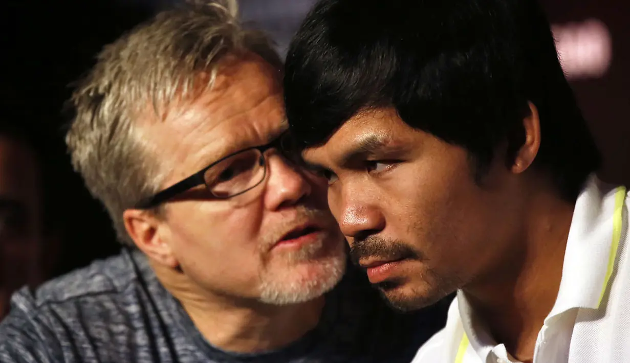 Petinju Filipina, Manny Pacquiao (kanan), mendengarkan arahan pelatihnya, Freddie Roach, dalam jumpa pers jelang laga melawan Chris Algieri di Shanghai, Tiongkok, (26/8/2014). (REUTERS/Carlos Barria)