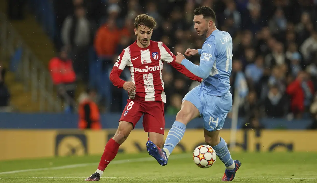 Penyerang Atletico Madrid, Antoine Griezmann berebut bola dengan bek Manchester City, Aymeric Laporte pada pertandingan leg pertama perempat final Liga Champions di Stadion Etihad, di Manchester, Rabu (6/4/2022). City menang tipis atas Atletico Madrid 1-0.   (AP Photo/Dave Thompson)