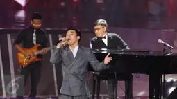 Yovie Widianto berkolaborasi dengan Mario di Konser Raya 22 Indosiar, Jakarta, Rabu (11/1). Konser Raya 22 Indosiar berlangsung meriah dengan menghadirkan musisi papan atas Indonesia dan Internasional. (Liputan6.com/Herman Zakharia)