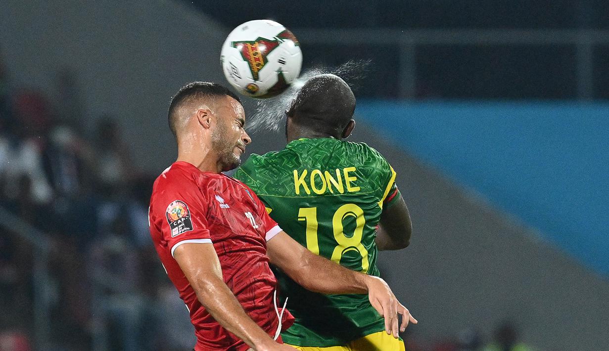 Gelandang Guinea Khatulistiwa Pablo Comitre Ganet (kiri) dan penyerang Mali Ibrahima Kone melompat saat berebut bola pada babak 16 besar Piala Afrika 2021 di Stadion Limbe, Kamis (27/1/2022) dini hari WIB. Guinea Ekuatorial mempermalukan Timnas Mali 6-5 (0-0) dalam adu penalti. (Issouf SANOGO/AFP)