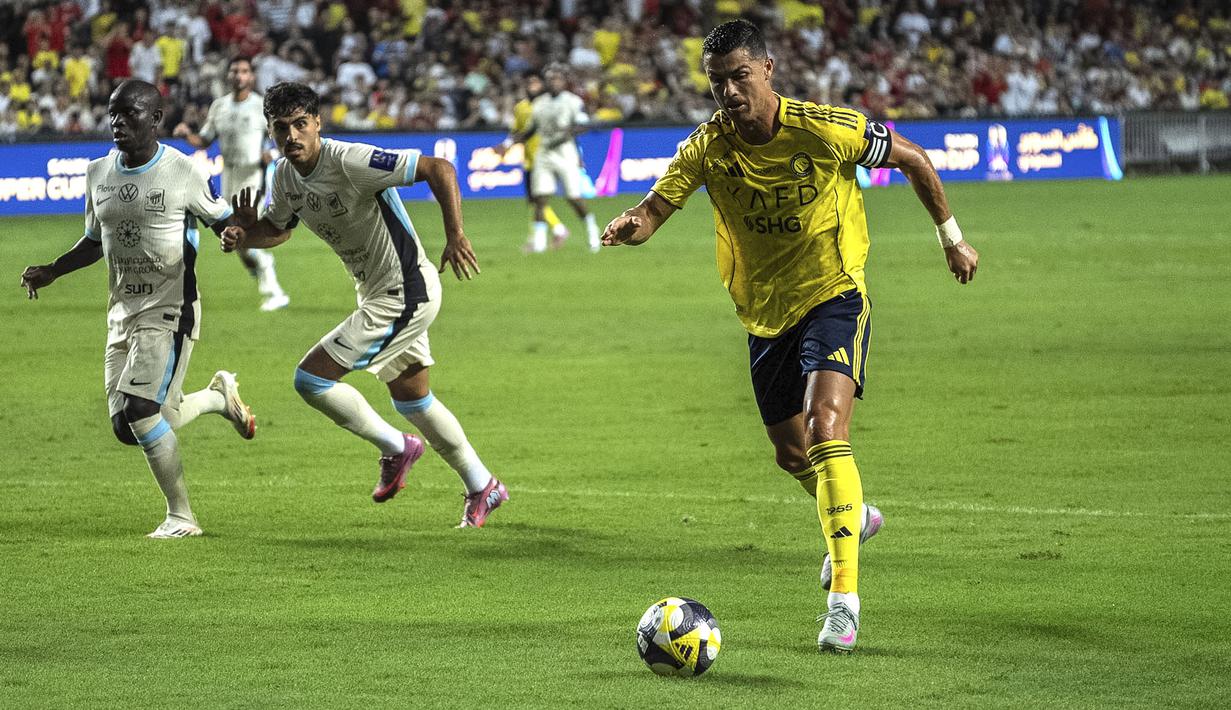 Pemain Al-Nassr, Cristiano Ronaldo menggiring bola dibayangi pemain Al-Ittihad dalam laga semfinal Saudi Super Cup 2025 di Hong Kong Stadium, Hong Kong, Selasa (19/08/2025) waktu setempat. (AP Photo/Chan Long Hei)