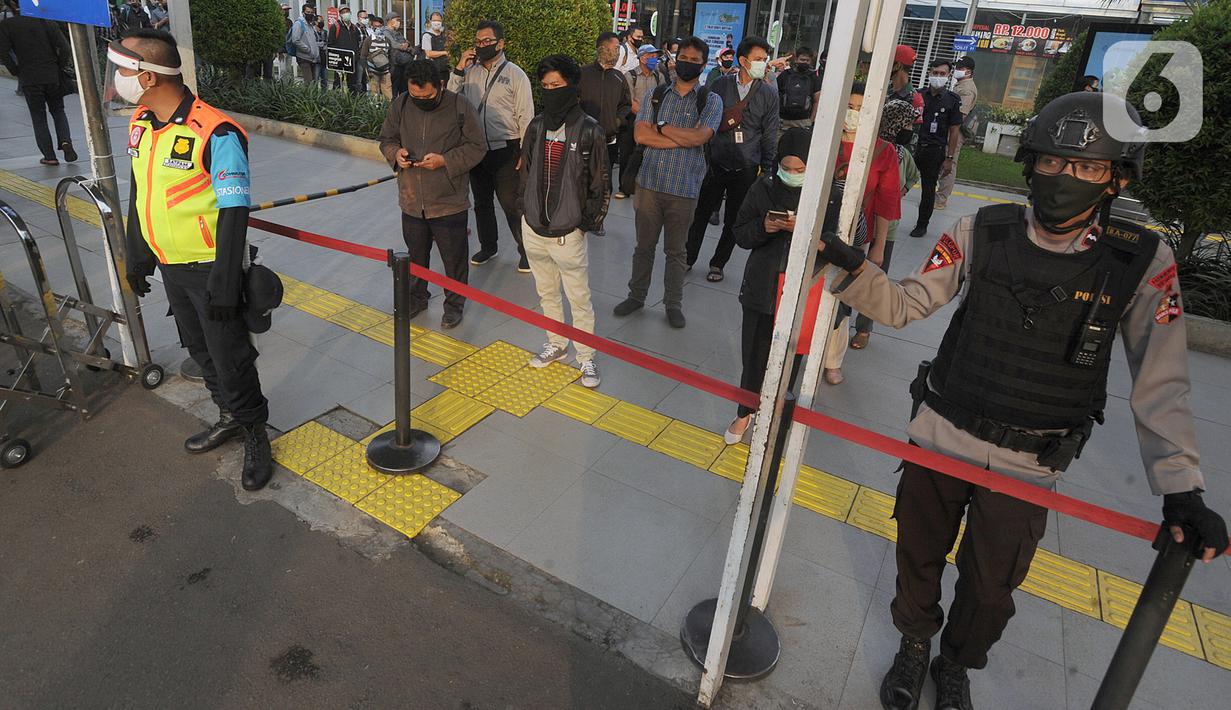 Aparat keamanan mengatur antrean penumpang KRL Commuterline di Stasiun Bogor, Jawa Barat, Selasa (9/6/2020) pagi. Puluhan polisi, TNI, Satpol PP, dan petugas stasiun diterjunkan untuk memandu penumpang mengantisipasi antrean panjang seperti kemarin. (merdeka.com/Arie Basuki)