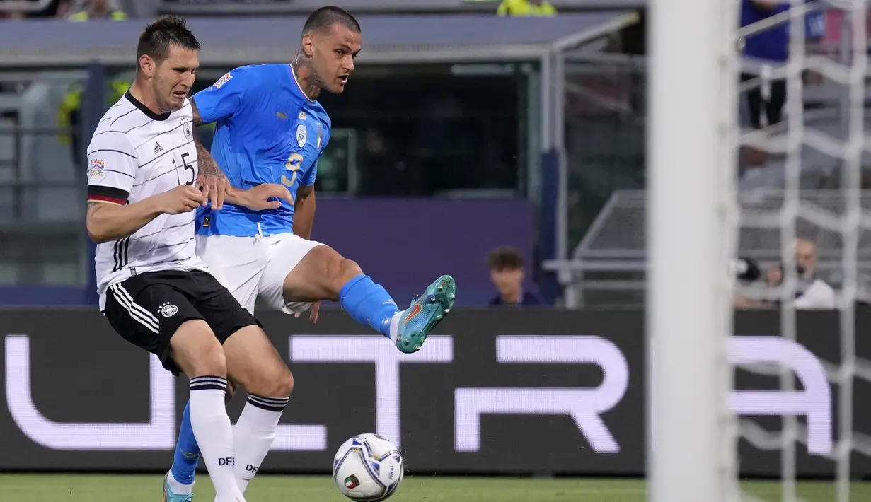 Bek timnas Jerman Niklas Sule mencoba untuk memblokir tembakan penyerang Italia Gianluca Scamacca pada matchday pertama UEFA Nations League A Grup 3 di Renato Dall'Ara, Minggu (6/5/2022) dini hari WIB. Jerman bermain imbang melawan Italia dengan skor 1-1. (AP Photo/Antonio Calanni)