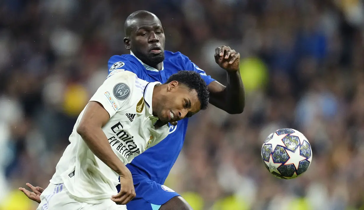 Pemain Real Madrid, Rodrygo (kiri) berebut bola dengan pemain Chelsea Kalidou Koulibaly pada laga leg pertama perempat final Liga Champions 2022/2023 di Santiago Bernabeu, Madrid, Kamis (13/04/2023) WIB. Los Blancos menang dengan skor 2-0. (AP Photo/Jose Breton)