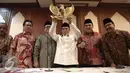 Ketua Umum PBNU KH Said Aqil Siradj mengangkat lambang negara Garuda Pancasila usai menggelar konferensi pers di Gedung PBNU, Jakarta, Senin (30/5). PBNU menyambut positif penetapan 1 Juni sebagai Hari Lahir Pancasila. (Liputan6.com/Faizal Fanani)