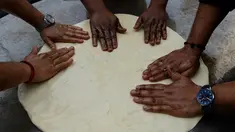 Koki India menyiapkan adonan untuk membuat roti goreng yang dikenal dengan sebutan Bhatura, India, New Delhi, Kamis (6/4). Penyelenggara berharap Bhatura buatan mereka bisa memecahkan rekor Bhatura  terbesar di India. (AFP PHOTO / SAJJAD HUSSAIN)
