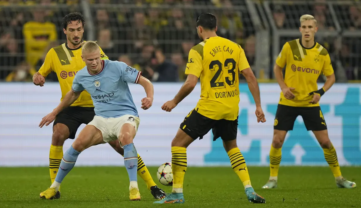 Penyerang Manchester City Erling Haaland bersaing dengan bek Borussia Dortmund Mats Hummels di Signal Iduna Park, Rabu (26/10/2022) dini hari WIB. Kedua tim kemudian sama-sama mengganti pemain dan taktiknya. Akan tetapi kedua tim sama-sama tak bisa mencetak gol sampai akhir laga.  (AP Photo/Martin Meissner)