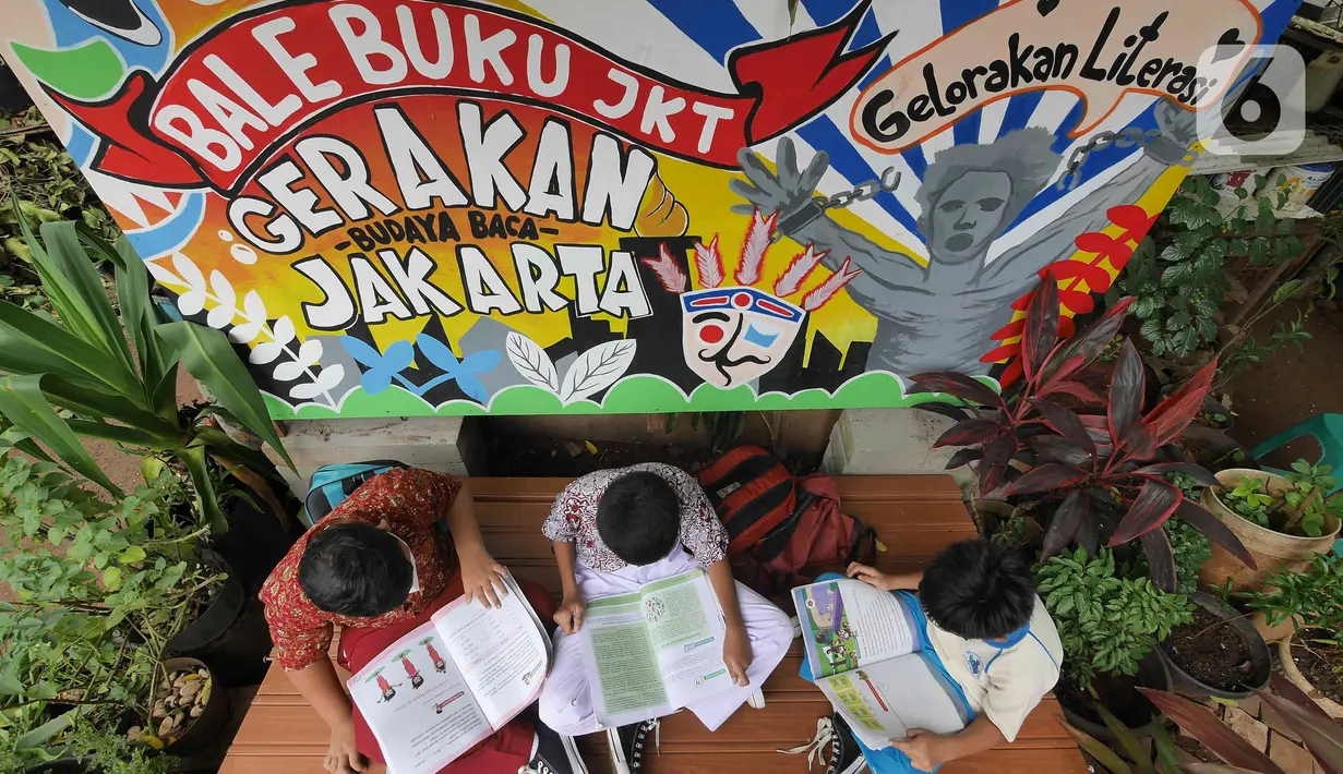 Anak-anak memilih buku untuk dibaca di pustaka mini Bale Buku, Kramat Jati, Jakarta Timur, Kamis (20/01/2022). Bale buku yang diresmikan pada Sabtu (15/1) dibangun dari barang-barang bekas oleh komunitas Baca Bale Buku. (Liputan6.com/Herman Zakharia)