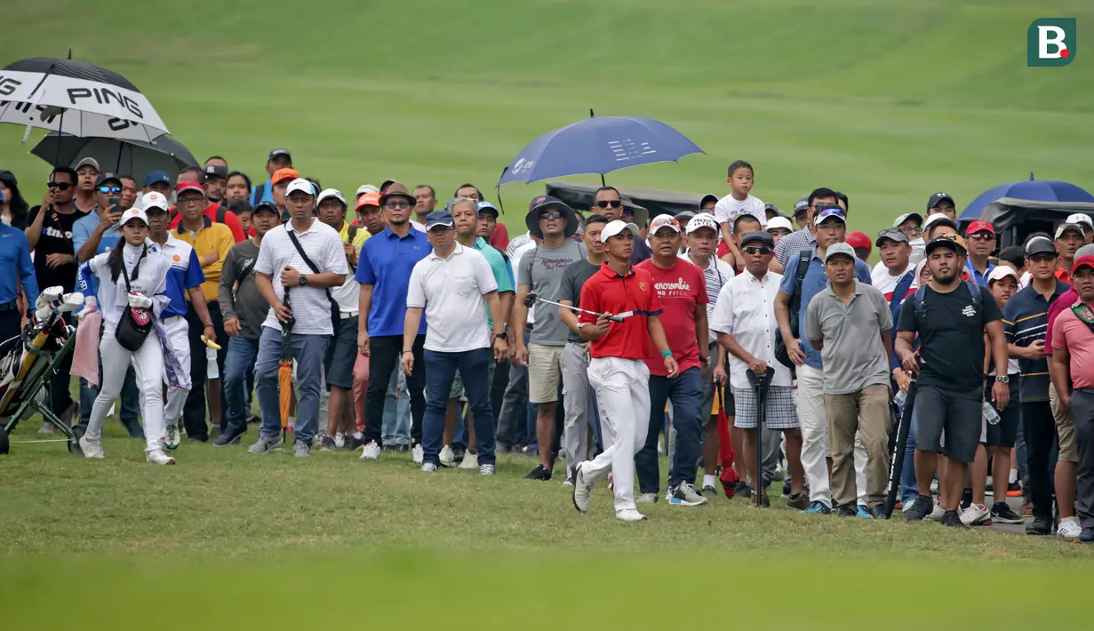 Ratusan penonton dengan setia mengikuti aksi Naraajie Emerald Ramadhan Putra (tengah) pegolf amatir Indonesia berusia 19 tahun yang sempat memimpin perolehan skor di turnamen golf pro BRI Indonesia Open 2019, Minggu (1/9/2019). (Bola.com/Peksi Cahyo)